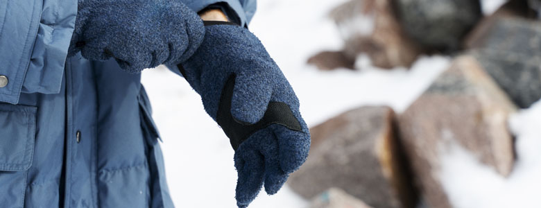 کوهنوردی درحال پوشیدن دستکش کوهنوردی